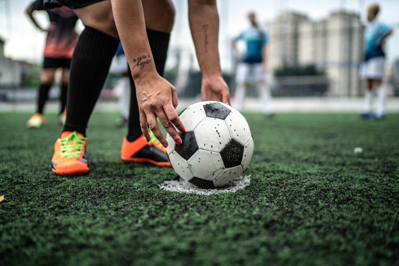 Low section of a female soccer player placing the ball for a free kick
